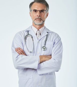 Portrait of confident doctor standing with his arms folded